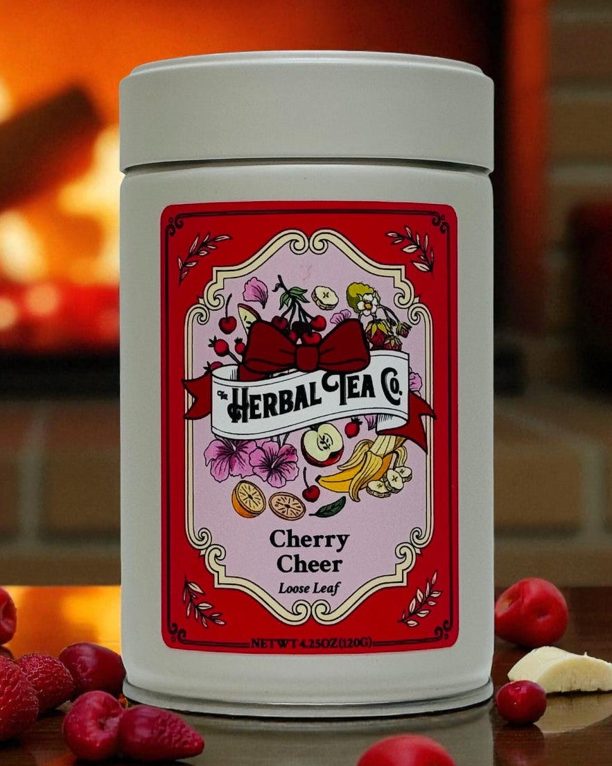 Herbal tea canister with cherry flavor label on a wooden surface in front of a fireplace.