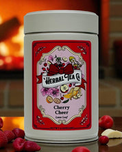 Herbal tea canister with cherry flavor label on a wooden surface in front of a fireplace.