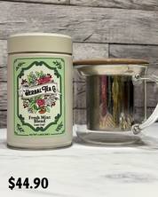 Herbal Tea Co. canister with a glass mug on a wooden surface, priced at $44.95.