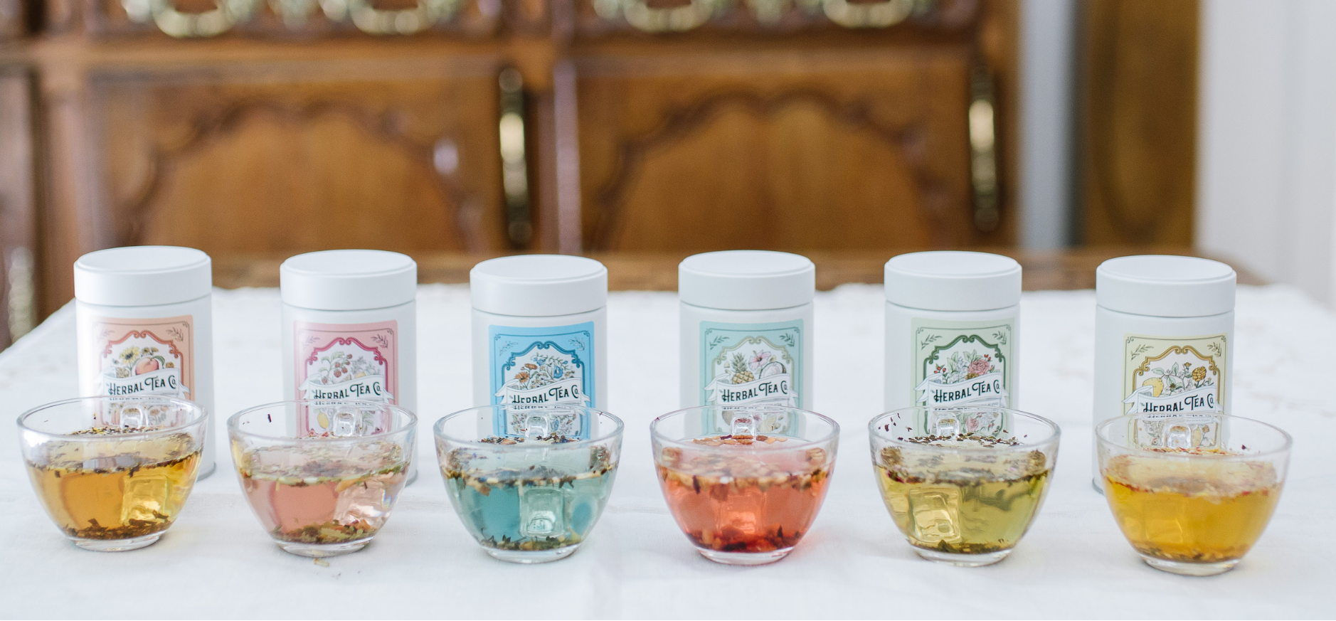 Assorted loose leaf herbal teas with visible labels on a table.