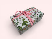 Gift box with floral pattern and pink ribbon on a white background