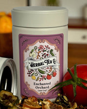 Herbal tea canister with a label on a kitchen counter with fruits.